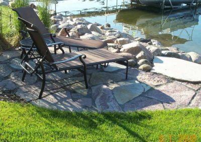 Waterfront patio landscaping by Greenside Inc in Savage, MN.